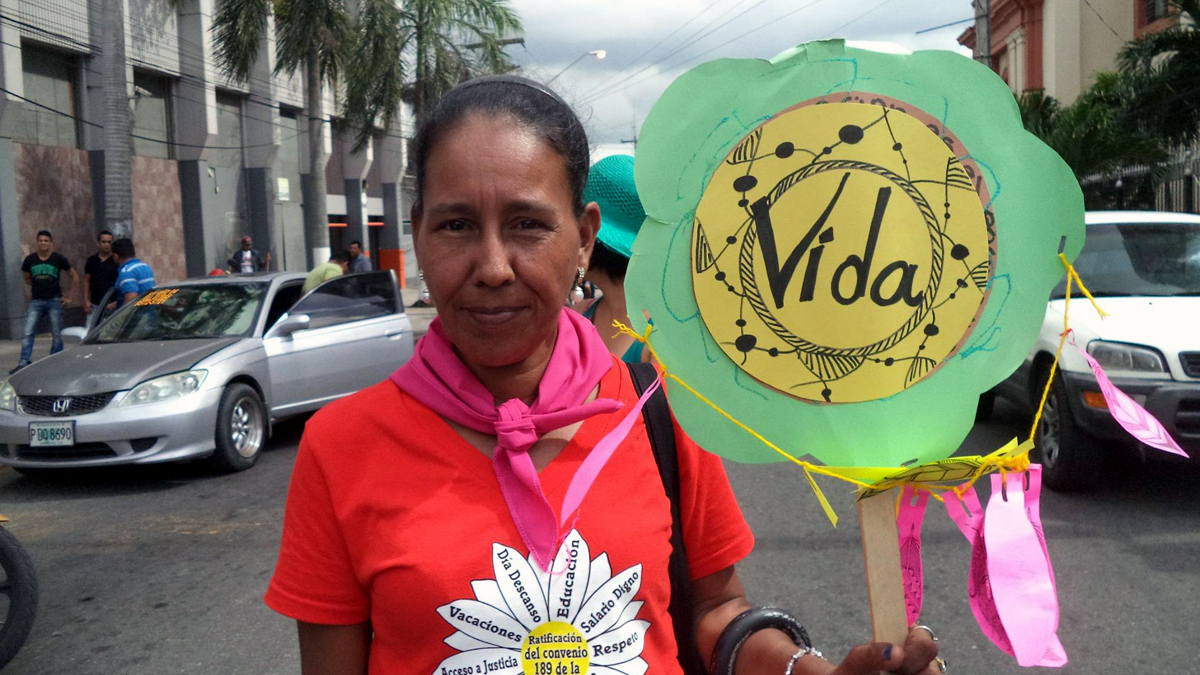 Eine Frau hält bei einer Demonstration ein Plakat mit der Aufschrift "Vida".