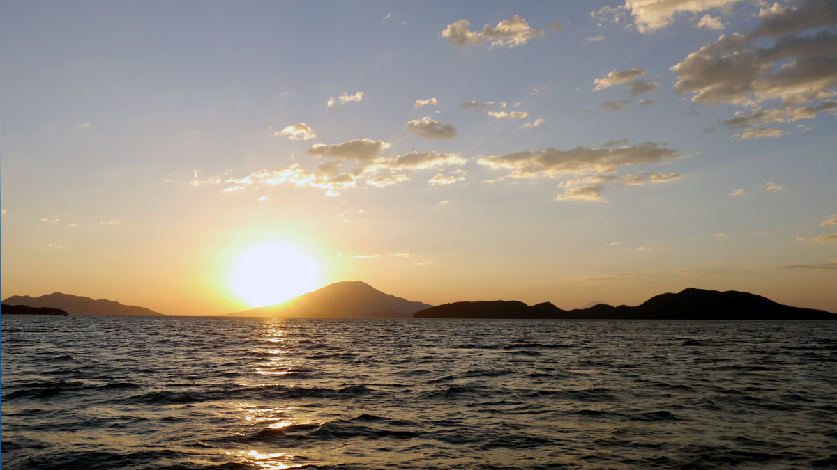 Sonneuntergang hinter einer Insel im Meer