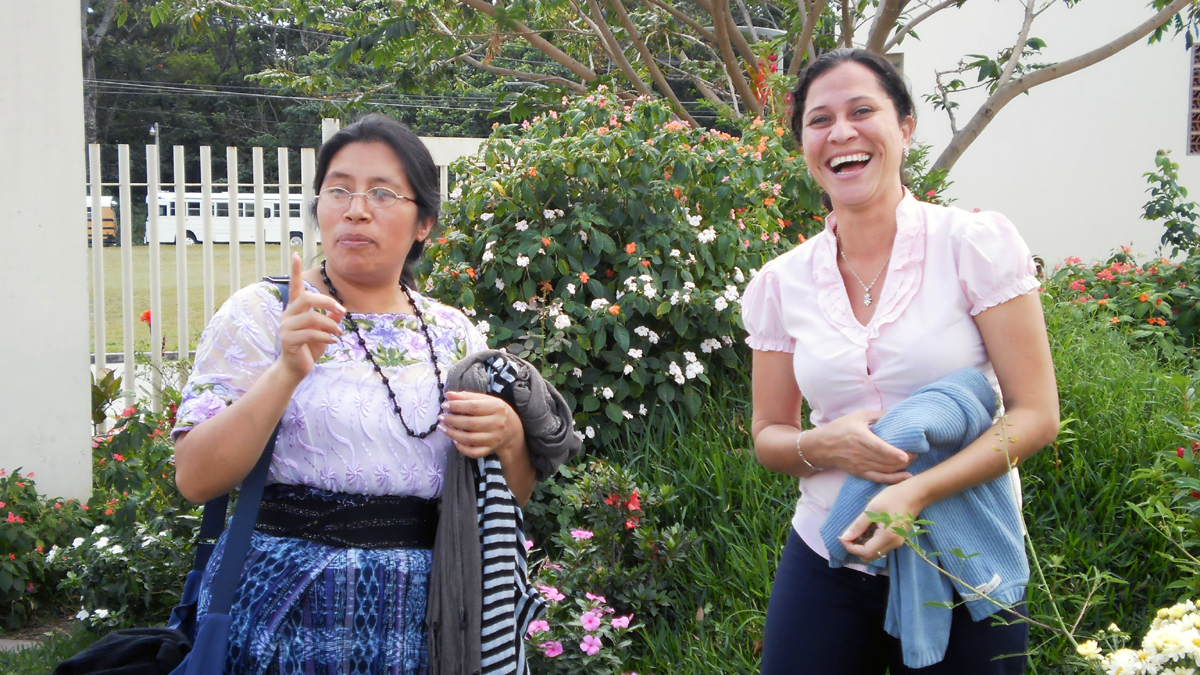 Zwei Teilnehmerinnen der Konferenz gegen Frauenmorde in El Savlador 2010 stehen lachend in einem Garten