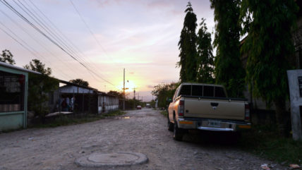Unbefestigte Straße druch ein Dorf südlich von El Progreso, Honduras, in der Abenddämmerung