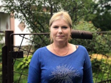 Näherin Angelica Manole steht vor einem Gartenzaun