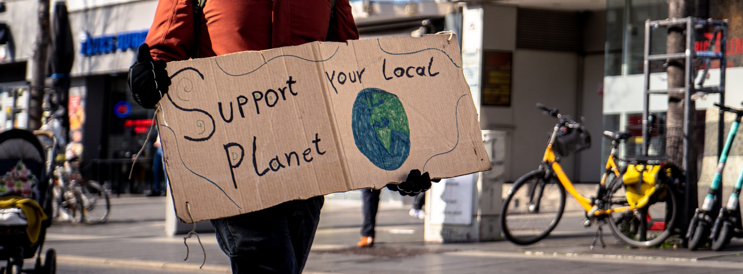 Demo-Schild: Support your local planet - Unterstütze deinen Planeten lokal