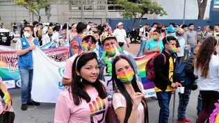 Viele Demonstrierende auf einem Bild, teils mit Regenbogenmaske.
